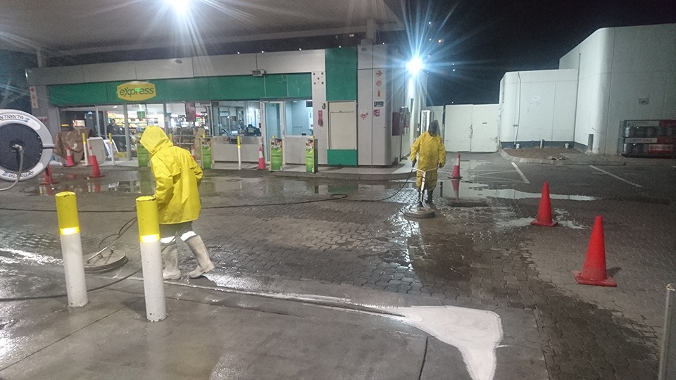 Night petrol station forecourt cleaning in Johannesburg with workers